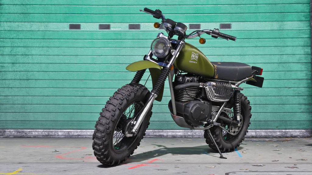 Green Vintage Dirt Bike with Knobby Tires Parked on a Concrete Surface in Front of a Teal Garage Door on Its Kickstand