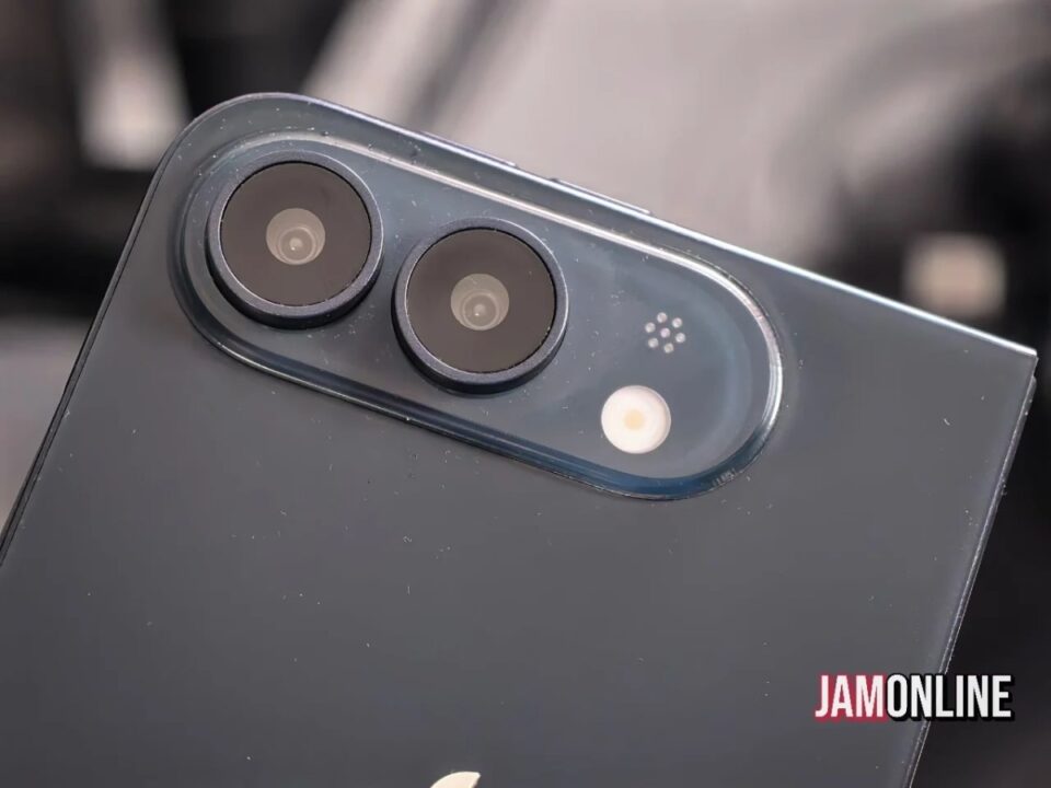 Close-up of a dark smartphone back featuring a dual-camera module with a flash and small sensor holes (JAMONLINE watermark).