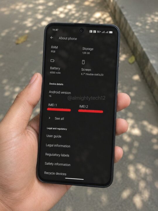 Hand holding a smartphone showing About phone screen with RAM 8GB, Storage 128GB, Battery 6000mAh, 6.7-inch AMOLED outdoors.