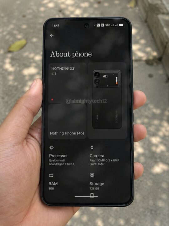 Hand holding a black smartphone showing the About phone screen with Nothing OS 4.1 and specs like RAM 8GB, storage 128GB, rear camera 50MP+8MP, outdoors on pavement