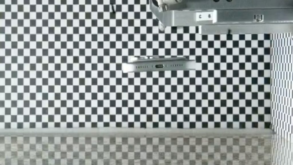 Room with black-and-white checkerboard wall tiles and a metal fixture mounted near the ceiling.