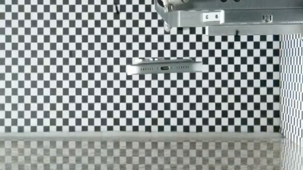 Room with black-and-white checkerboard wall tiles and a metal fixture mounted near the ceiling.