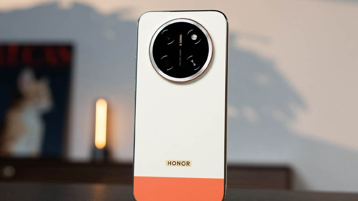 Honor smartphone shown from the back with a large circular camera module on white casing and an orange bottom edge.