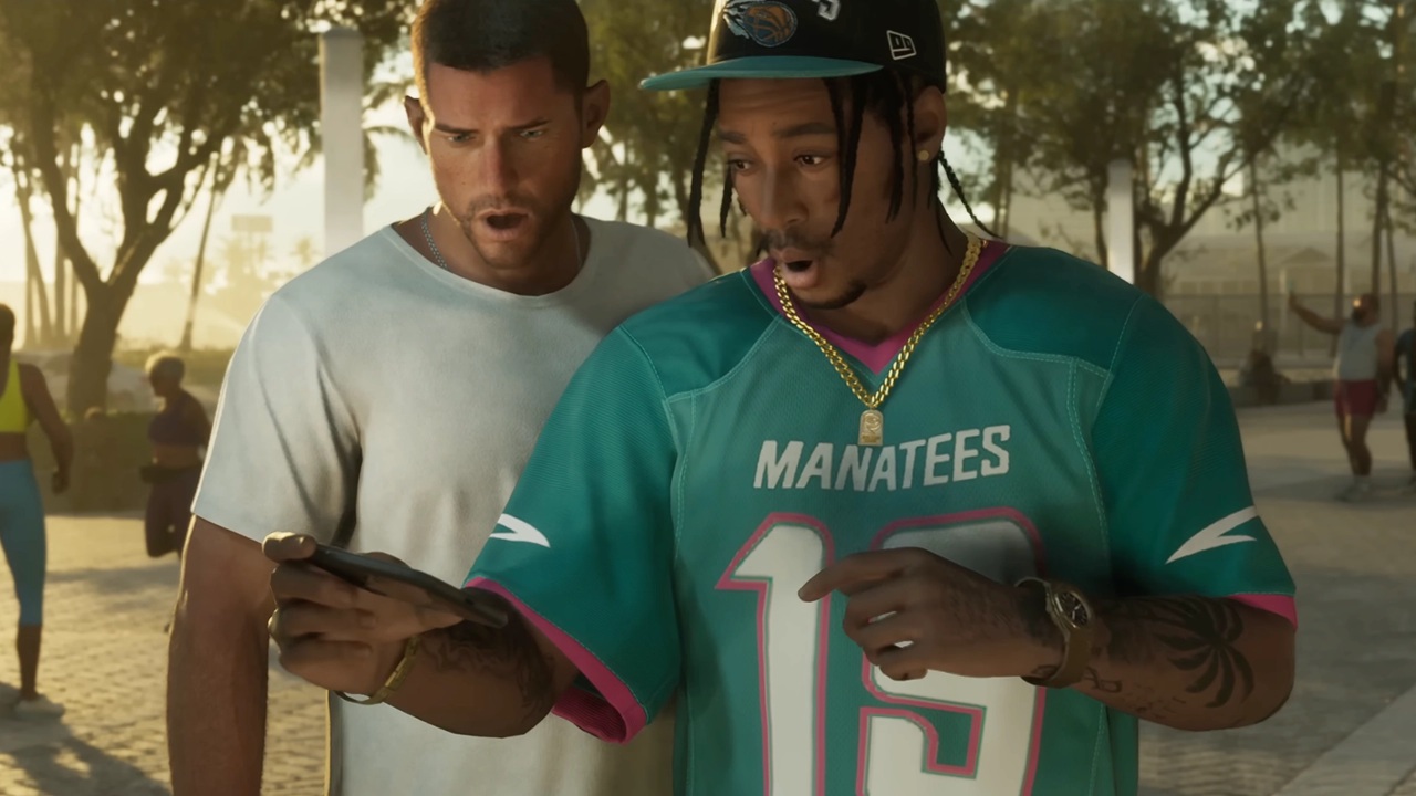 Two Men Outdoors One in a Teal Manatees Jersey 13 Looking at a Smartphone with the Other Man Closely Behind Him