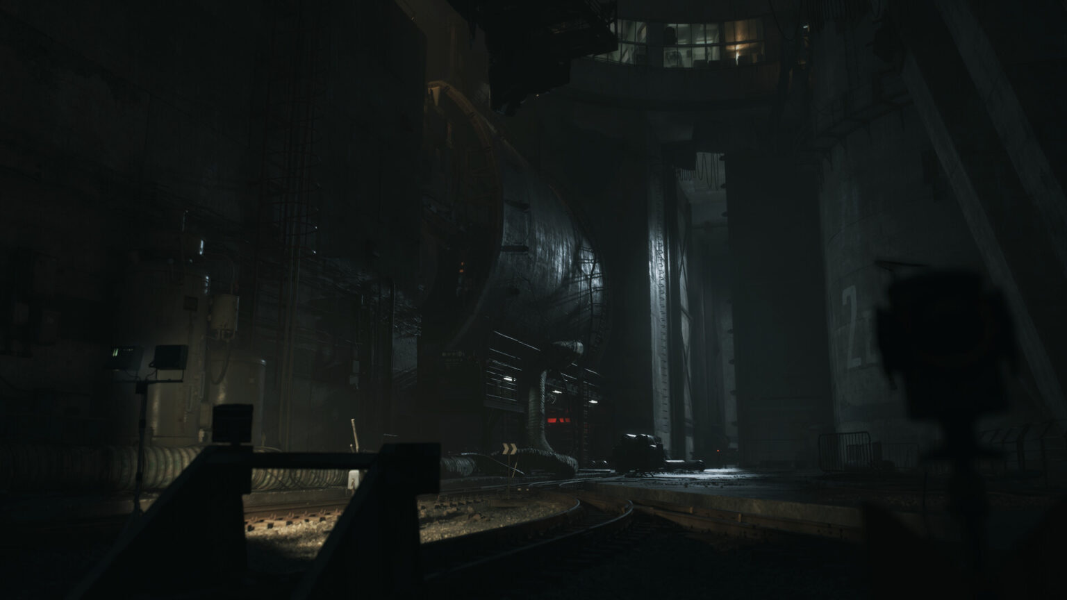 Dim Underground Industrial Tunnel with Heavy Machinery Curved Rails and Scattered Equipment Illuminated by Low Ambient Light in the Distance