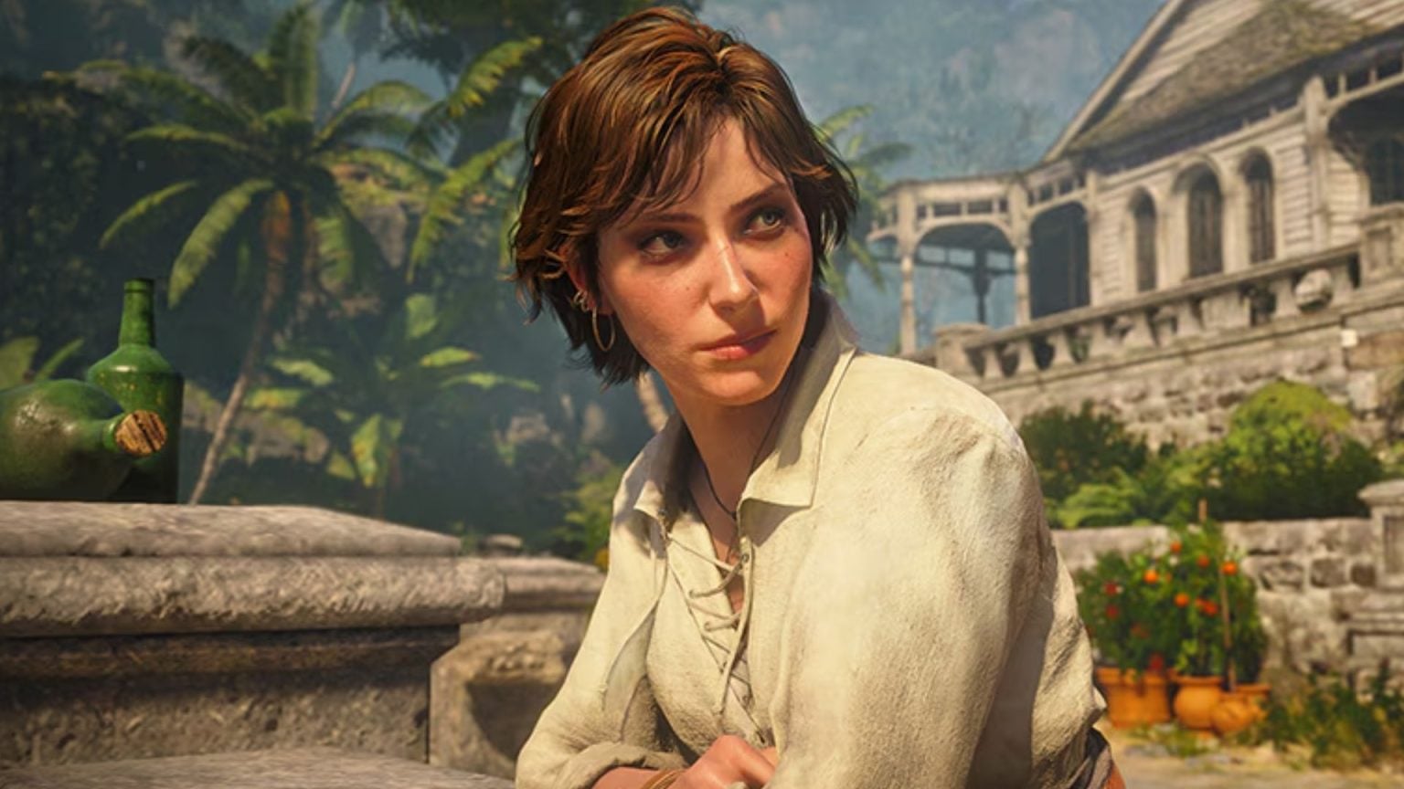Woman with Short Brown Hair in a Light Blouse Sits at a Stone Railing with a Tropical Garden and a Historic Building in the Background