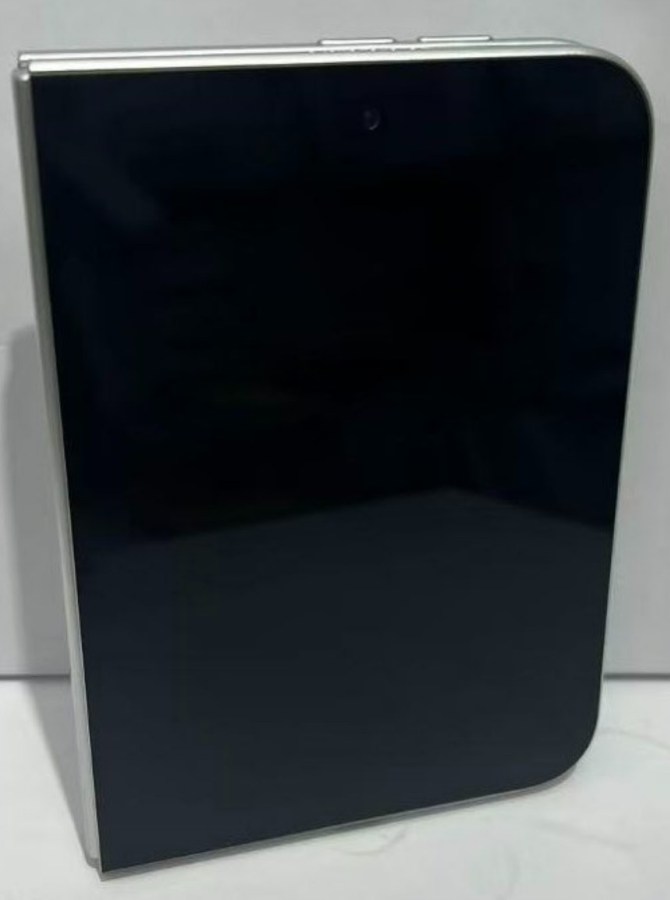 1000041316 Black, tall rectangular electronic device with rounded right edge and silver trim at the top edge showing control buttons.