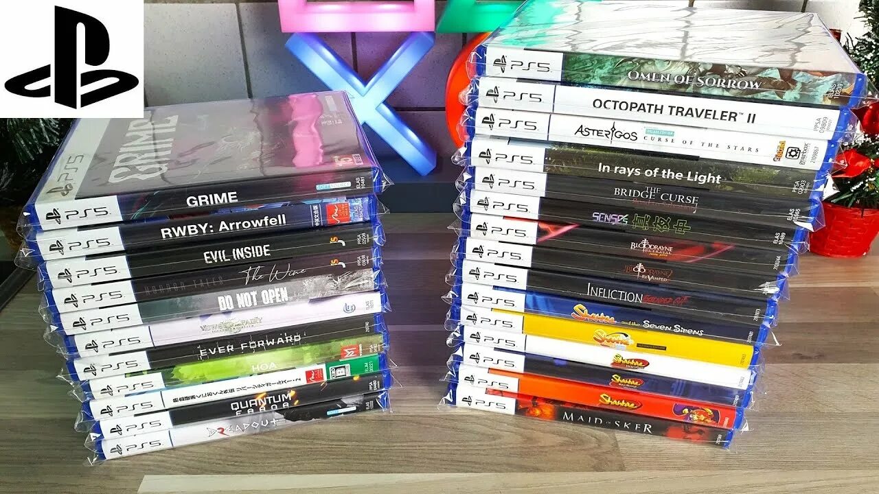 Two Stacked Piles of Playstation 5 Game Cases on a Table with a Ps5 Logo in the Corner Suggesting a Game Collection
