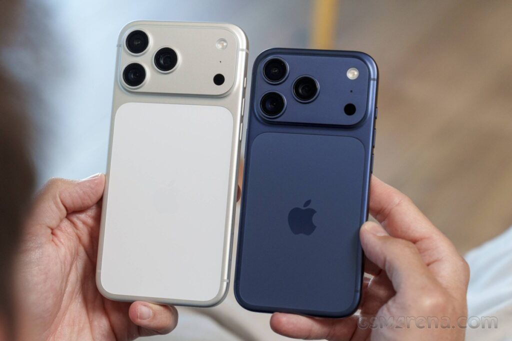 Two iPhones held side by side, white and blue, showcasing triple-camera modules on the backs.
