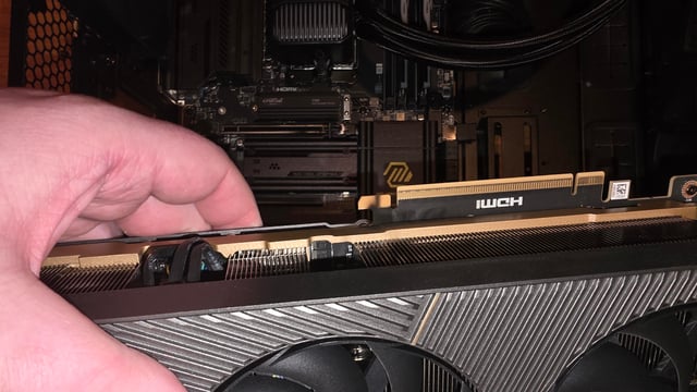 Close up of a Hand Installing a Graphics Card into a Pc Motherboard Pcie Slot and Cooling Fan Visible