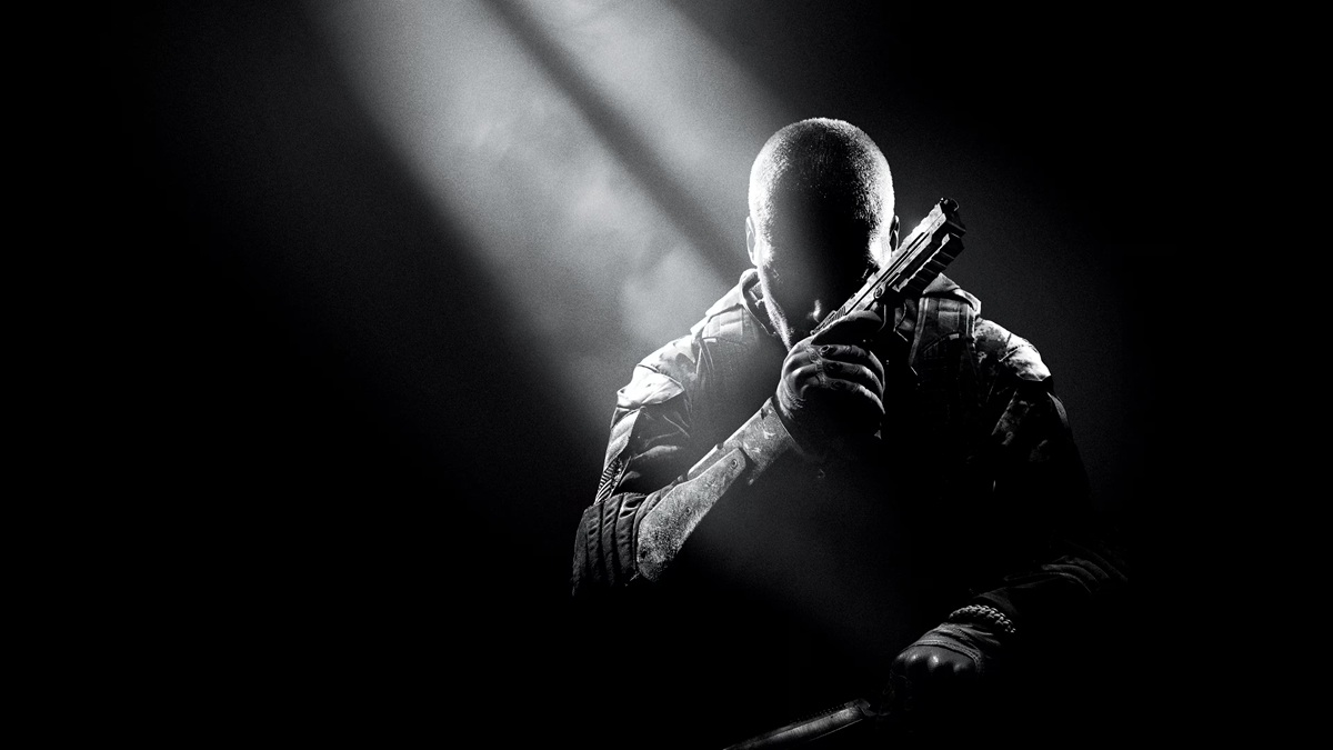 Silhouetted Soldier in Tactical Gear Holding a Handgun Across the Chest Under a Spotlight in a Dark Scene