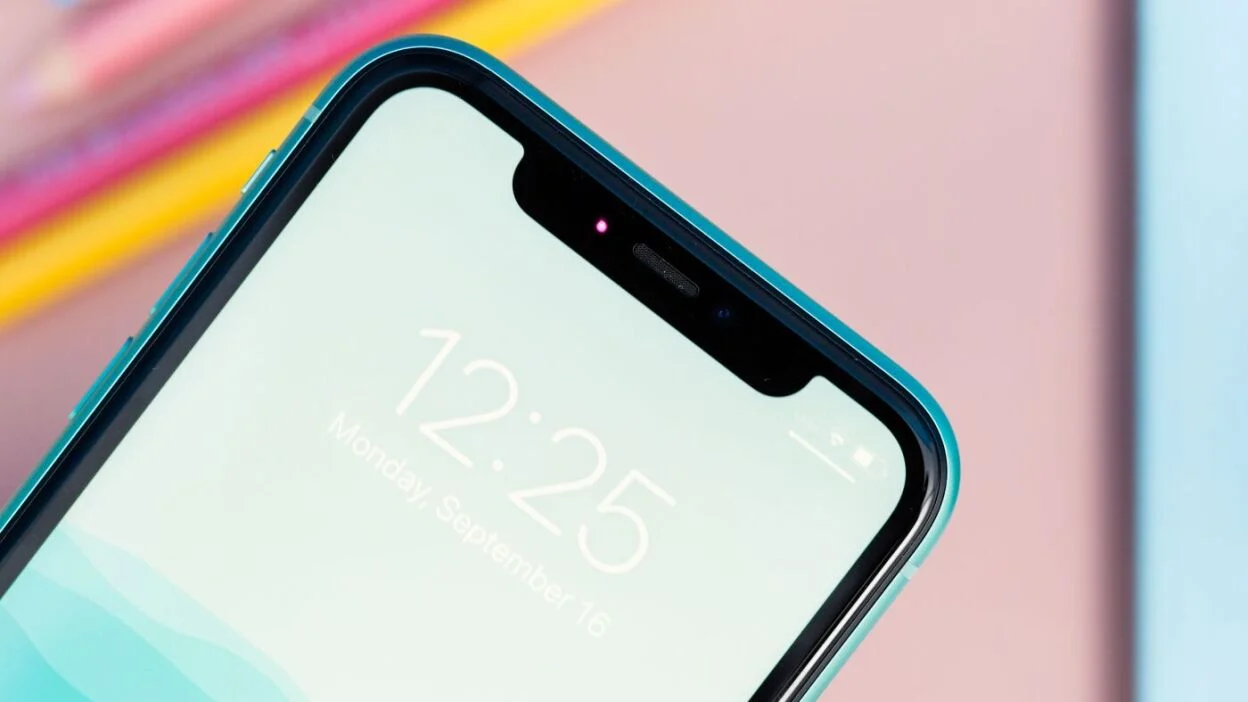 Close-up of a turquoise-edged smartphone at an angle, displaying a light lock screen with time 12:25 and date Monday, September 16.