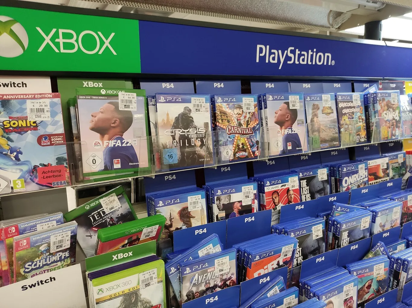 Store Shelf Featuring Xbox and Playstation Sections Ps4 Game Cases Like Fifa 22 and Crash Visible on the Display