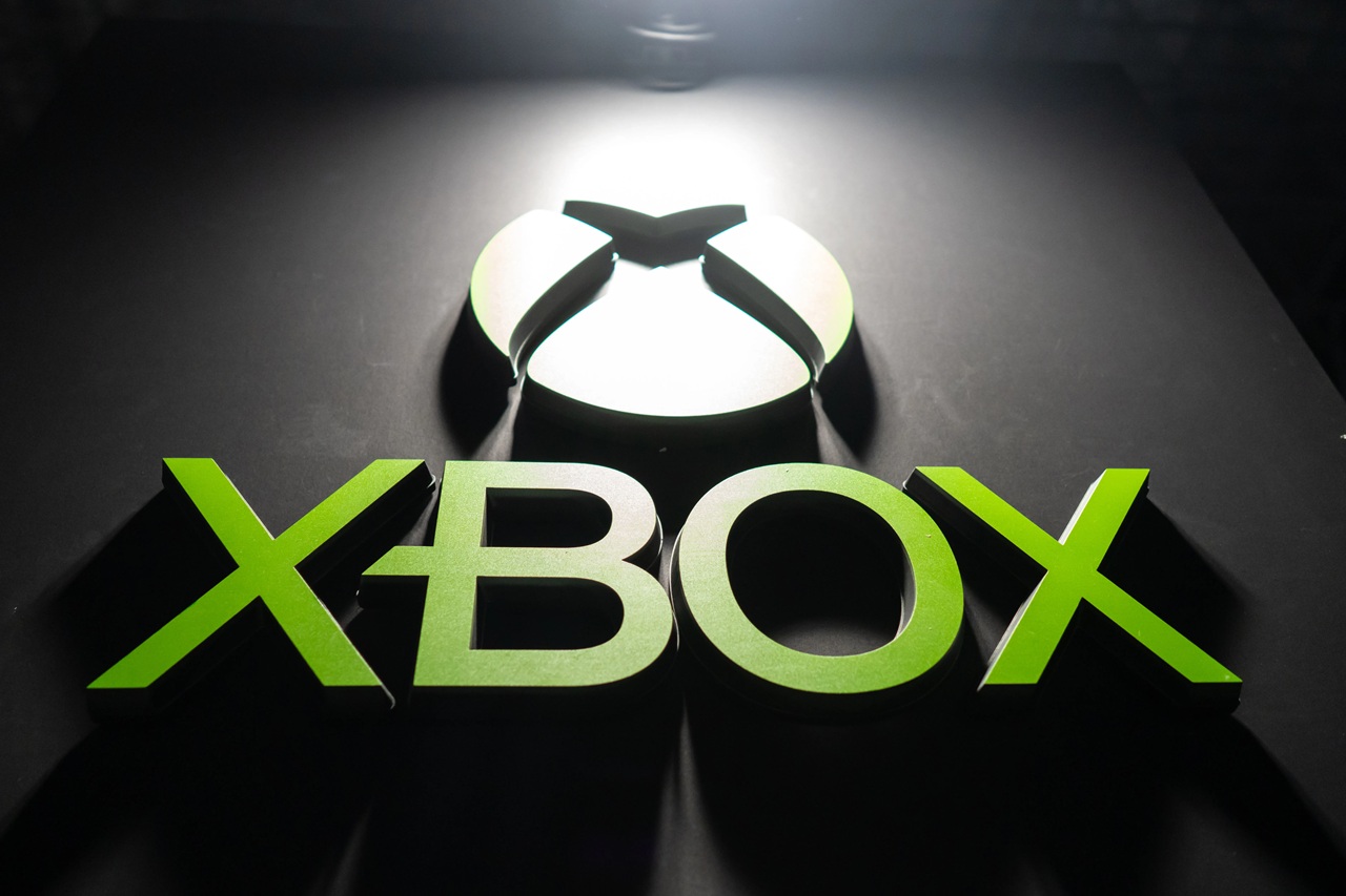 Xbox Logo Sign in Bright Green Lettering on a Dark Surface with a Circular Light Feature Above