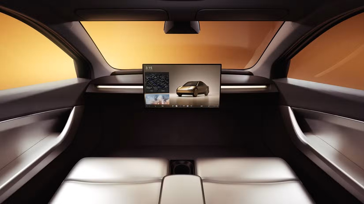 Futuristic car interior with a large central touchscreen showing a gold car model against an orange-lit background in a minimal cabin
