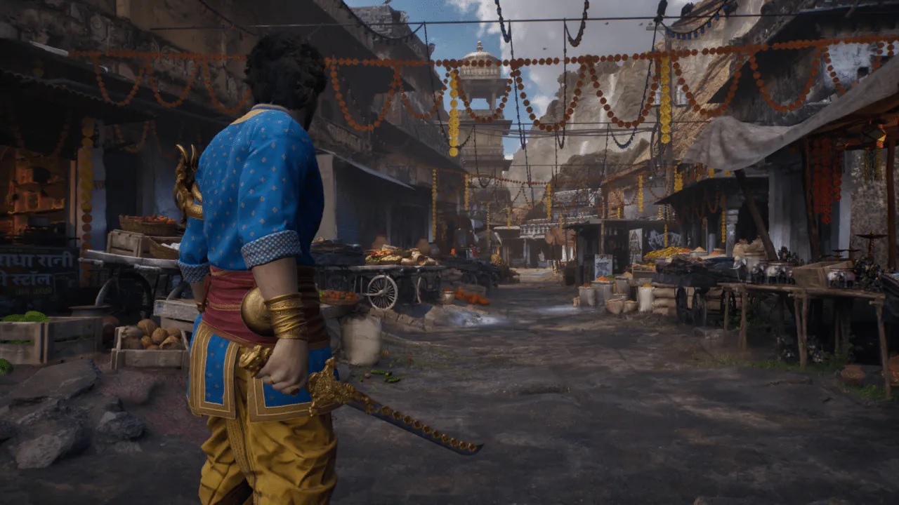Man in Blue and Gold Traditional Costume with a Sword Standing in a Decorated Market Street Viewed from Behind