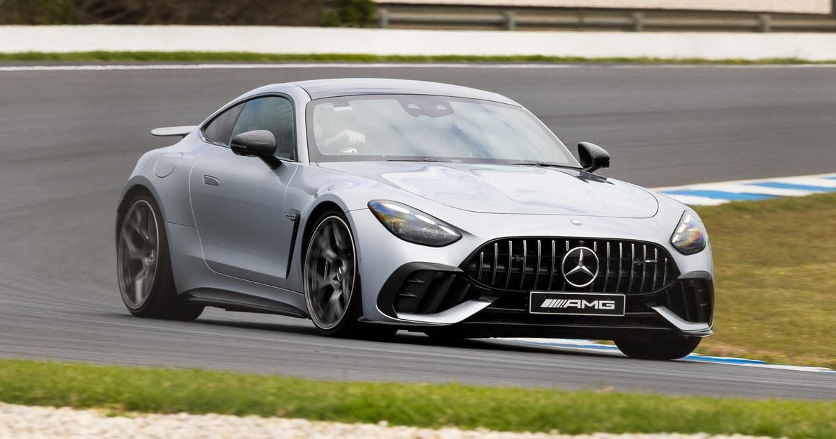 1000042747 Silver Mercedes-AMG GT sports car around a bend on a race track, front three-quarter view