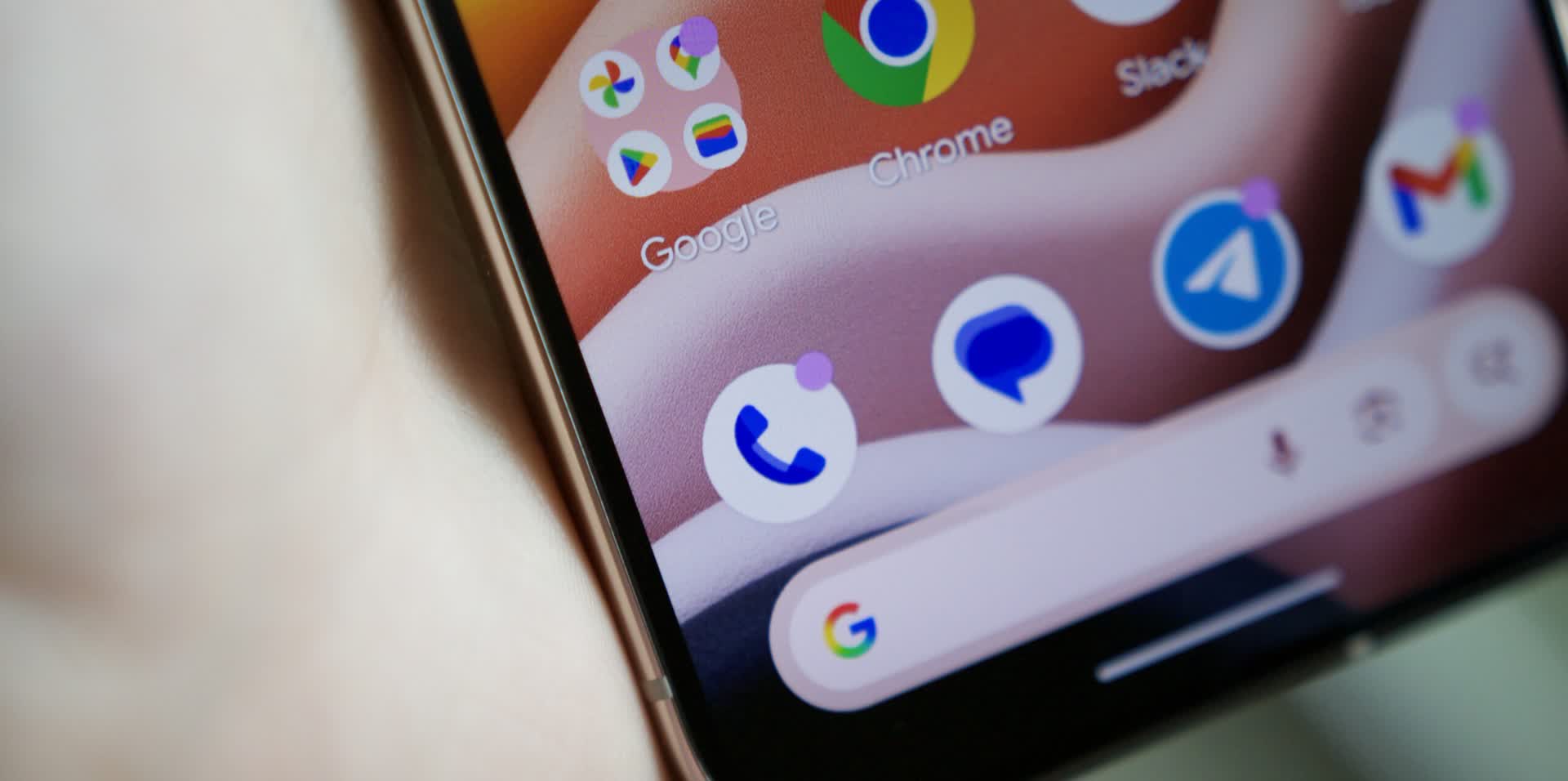 Close-up of a smartphone home screen with app icons, including Google and Chrome, on a curved display edge.