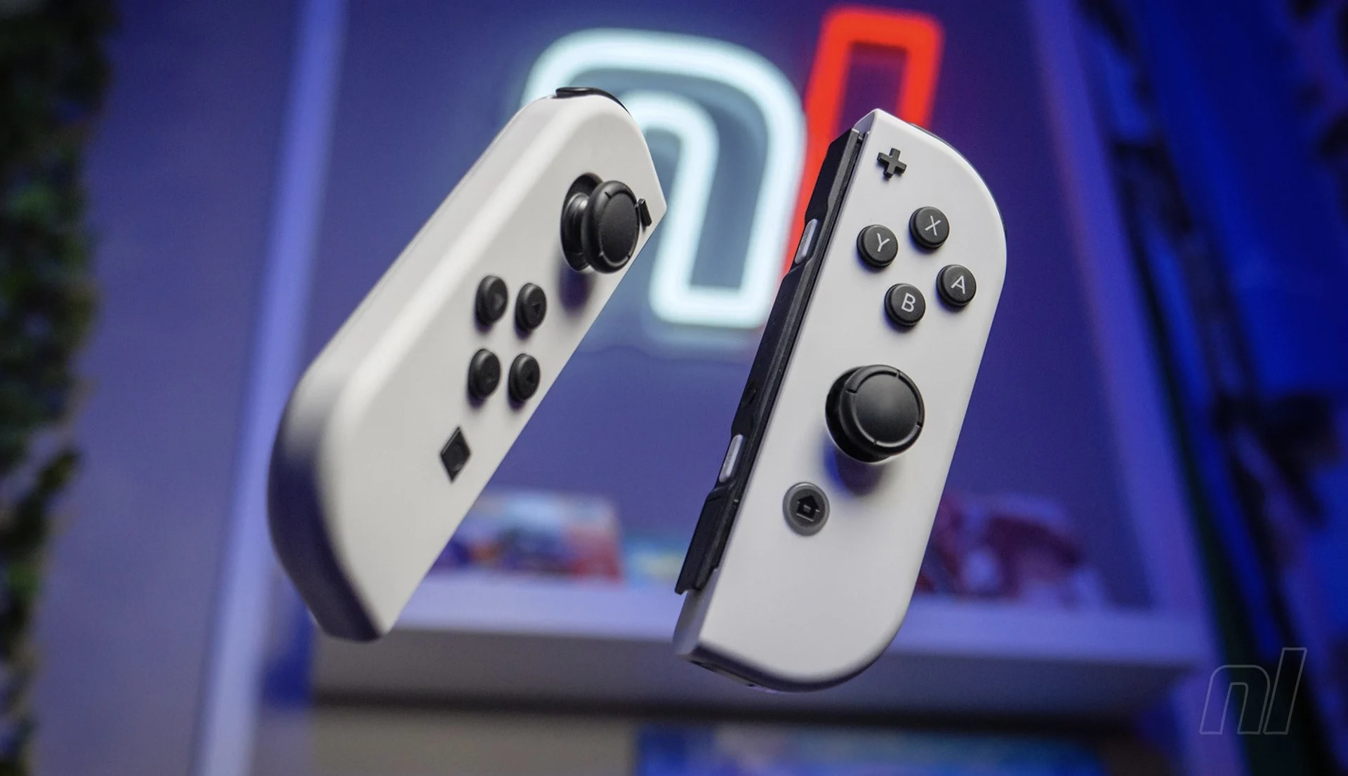 Two Gray Nintendo Switch Joy con Controllers Appear to Float in Front of a Neon lit Background Ready for Gaming