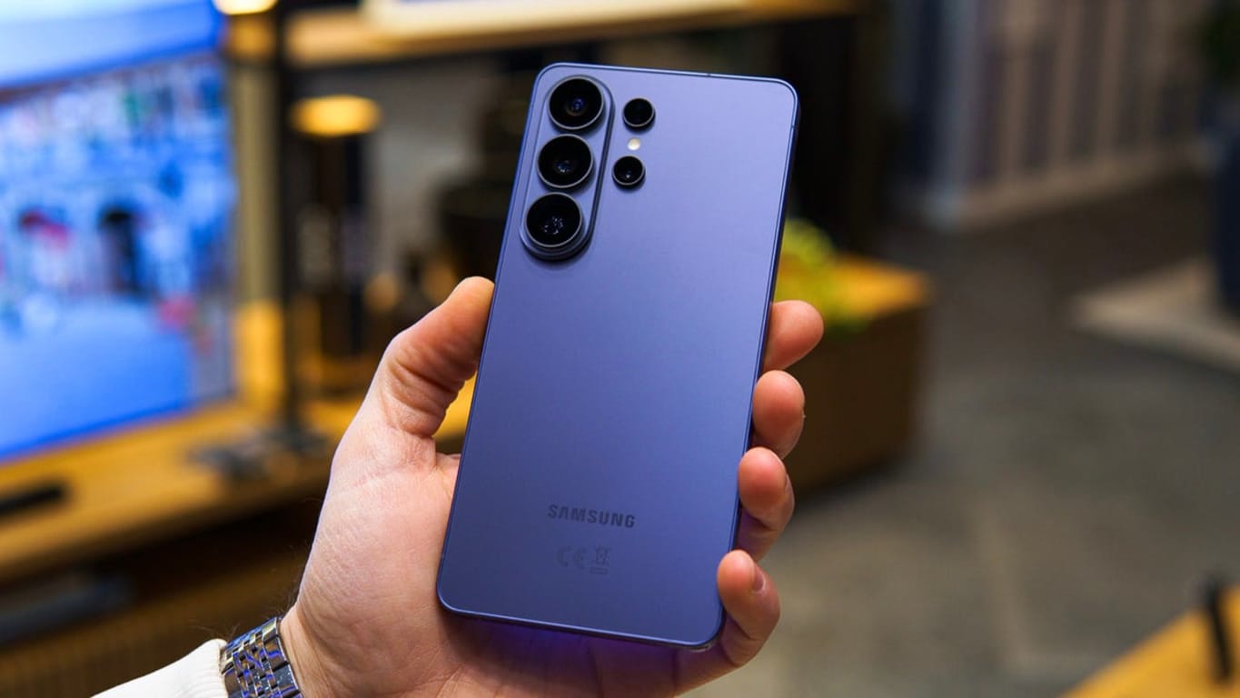 Purple Samsung Galaxy phone held in a hand, showing its quad rear camera module.