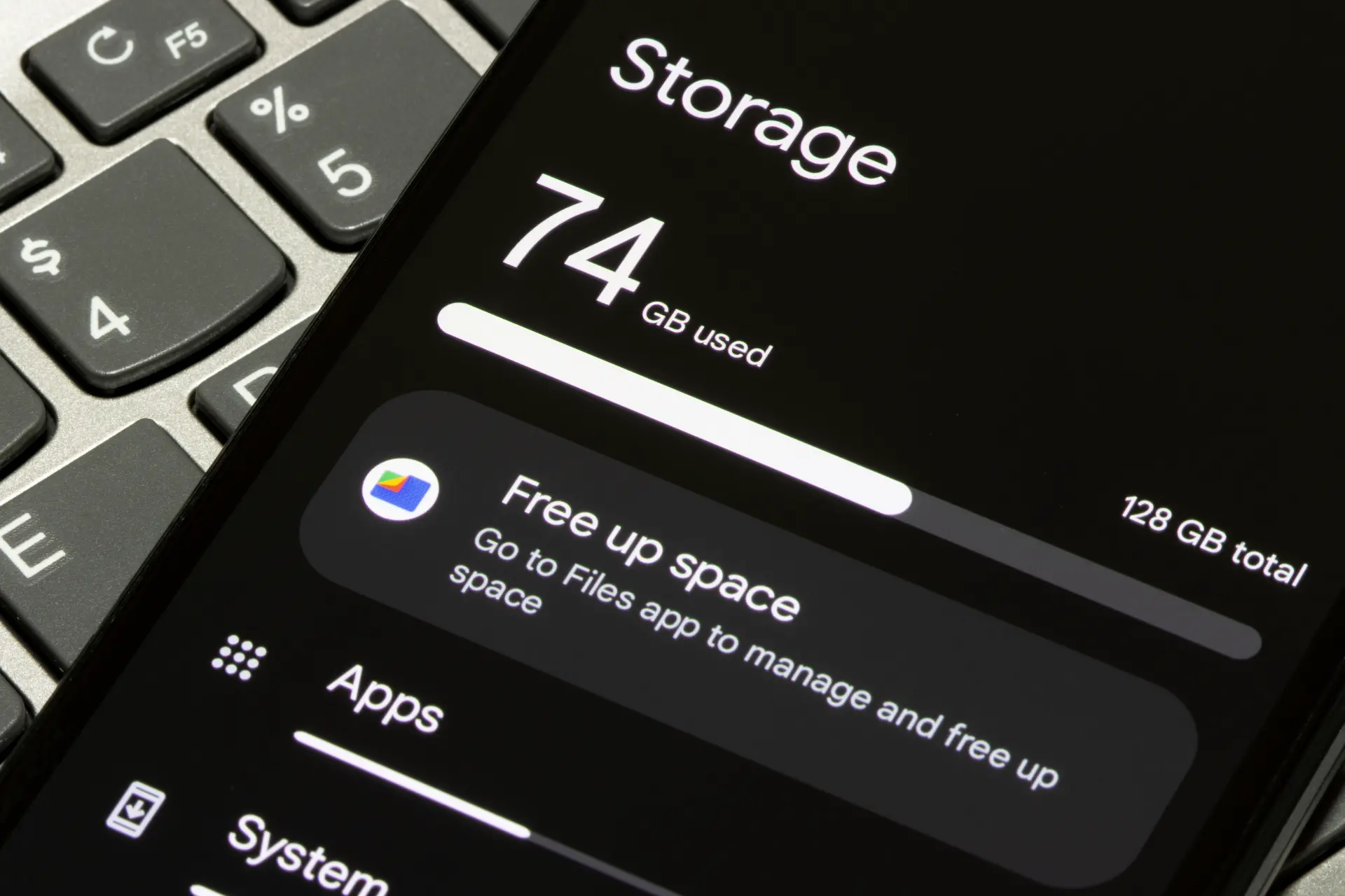 Phone screen shows storage usage: 74 GB used of 128 GB, with a 'Free up Space' banner visible.